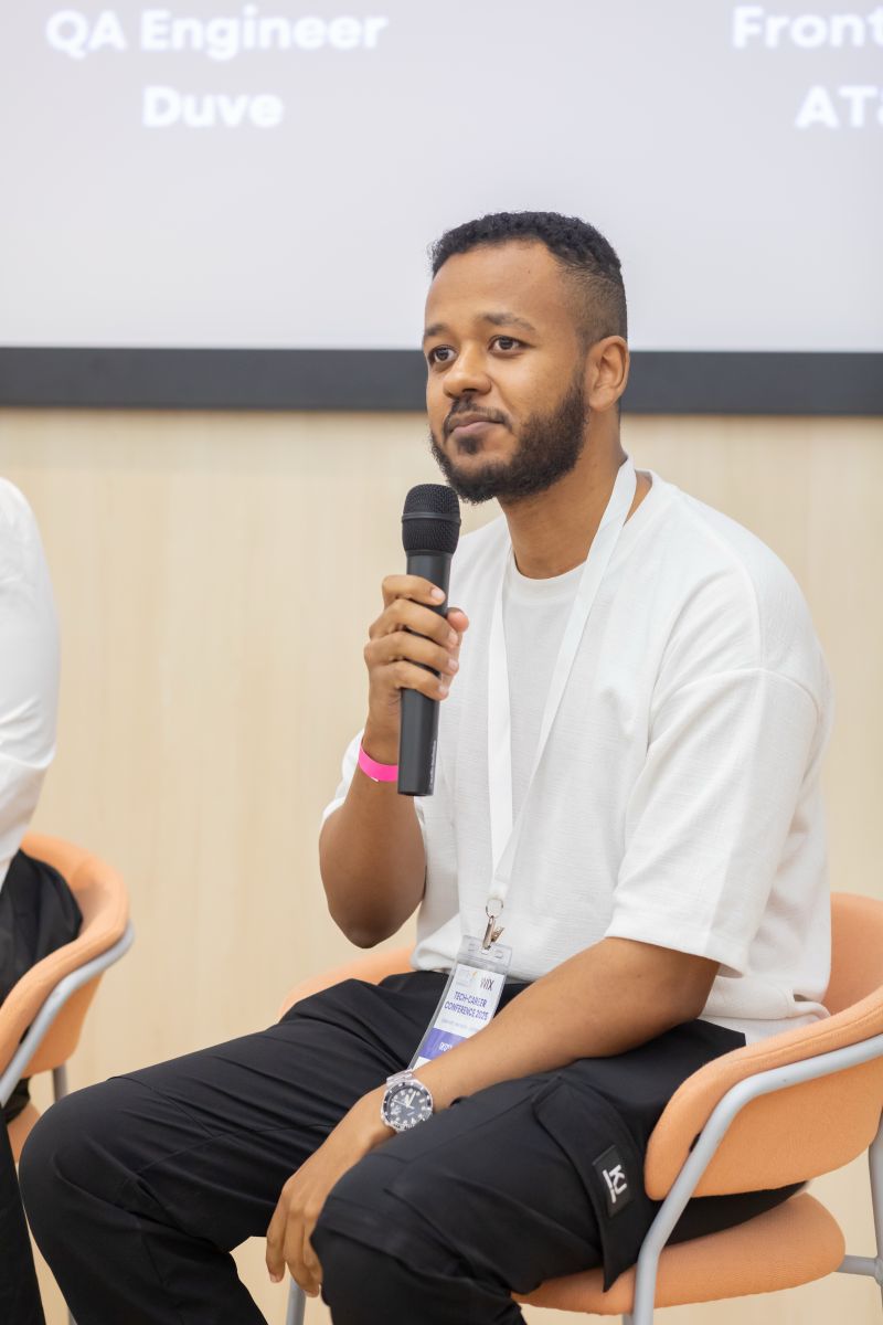 Yonatan Bitew speaking with a microphone at a Tech-Career convention event.