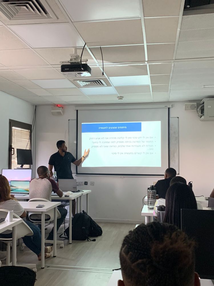 Yonatan teaching Tech-Career software engineering students in a classroom.